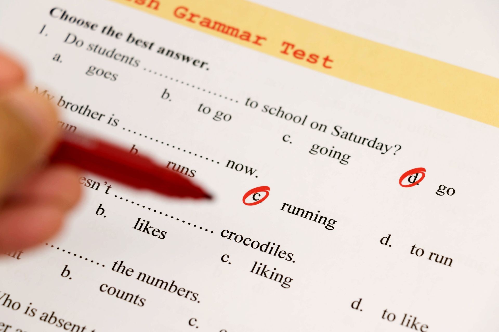 English grammar test sheet on wooden desk